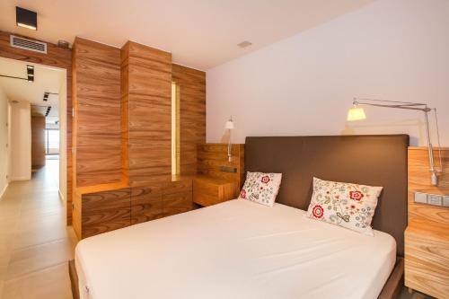 滨海托萨Tossa de Mar Beach的一间卧室设有一张床和木墙