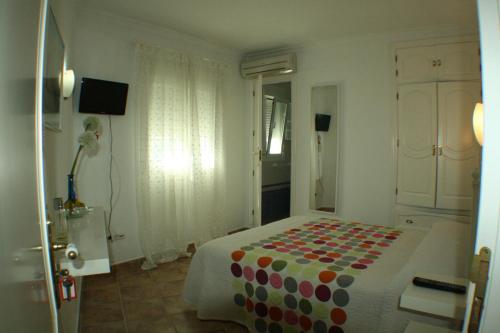 科尼尔-德拉弗龙特拉伊莎贝尔的角落旅馆的一间卧室配有一张带波卡圆毯的床
