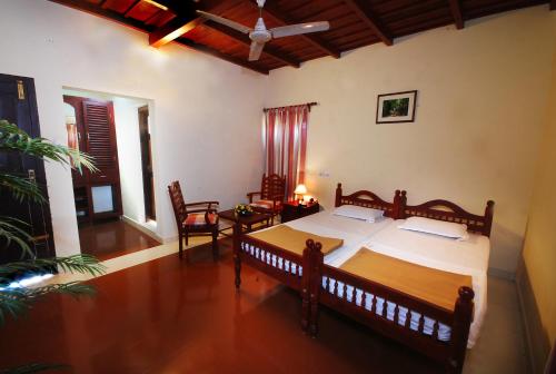 ThirunelliAgraharam Resorts的卧室配有一张床和一张桌子及椅子
