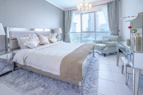 迪拜Elite Royal Apartment - Full Burj Khalifa & Fountain View - Premier - 2 bedrooms & 1 open bedroom without partition的白色卧室配有一张大床和一张书桌