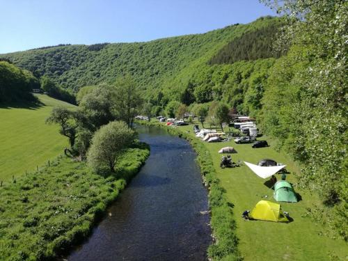 迪尔巴克Taos Single - Camping Du Nord的山边草上带帐篷的河流