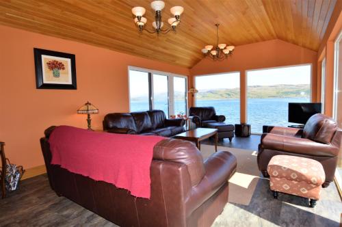 KamesTaigh na Mara的客厅配有真皮沙发和椅子