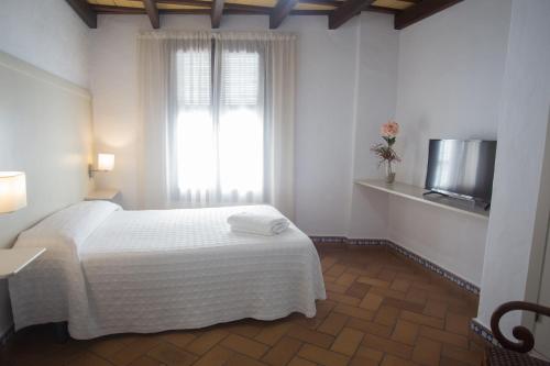 科尼尔-德拉弗龙特拉Hostal Santa Catalina的卧室配有白色的床和窗户。