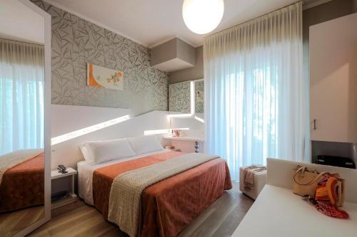 里米尼Hotel Ombretta Mare的酒店客房,配有床和镜子