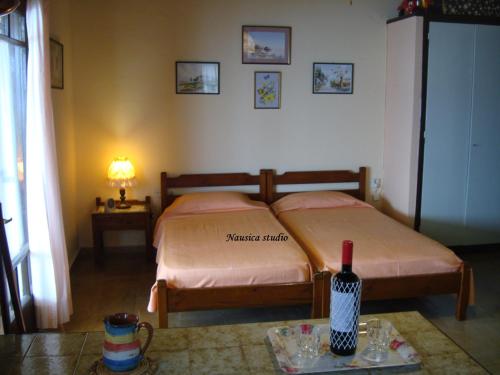 Agia Pelagia ChlomouStudio Nausica... a sense of paradise!的一间卧室配有一张床和一张桌子及一瓶葡萄酒