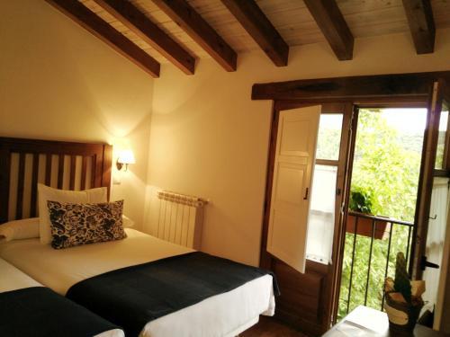 Lomeña费德拉旅馆的一间卧室设有两张床和滑动玻璃门