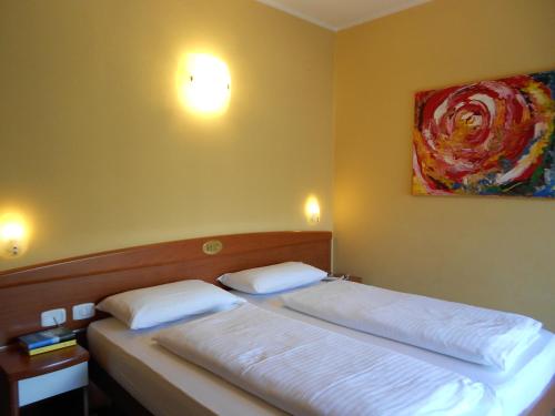 彼得拉穆拉塔Hotel Ristorante Daino的一间卧室设有两张床,墙上挂着一幅画