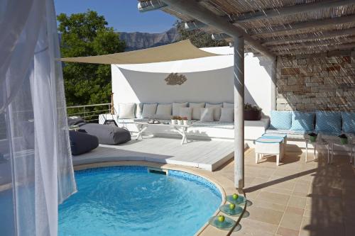 克里斯阿穆迪亚Mare Monte Small Boutique Hotel的一个带游泳池和遮阳伞的庭院