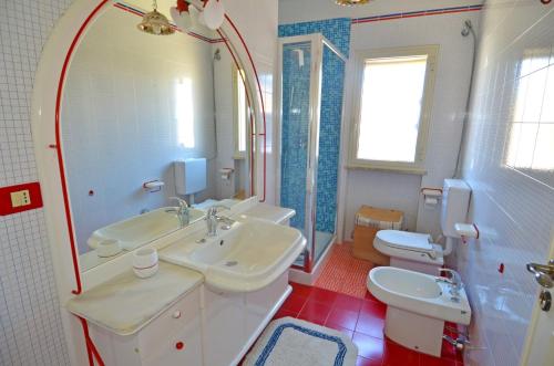 莱乌卡Casa Tramonto - RosariaVacanze的浴室设有2个水槽、卫生间和镜子。