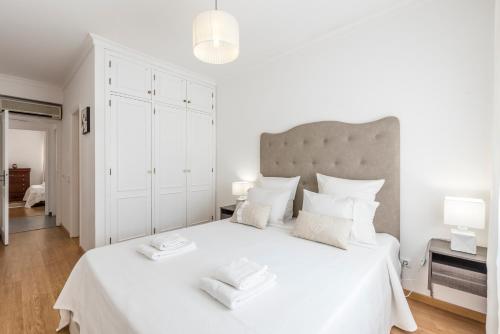 阿尔布费拉Albufeira Oldtown 330ft Beach Parking AC Wifi的白色卧室配有一张大白色床和2条毛巾