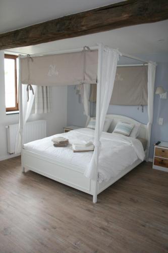 RixensartLa Ferme Remue的一间卧室配有一张带天蓬的白色床