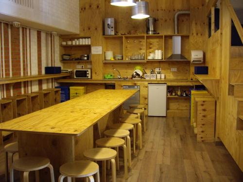 阿尔苏阿O Albergue de Selmo的一个带大型木制柜台和凳子的大厨房