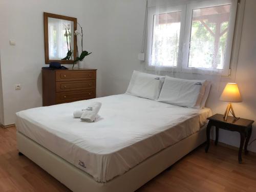 耶拉基尼Villa Stella的卧室配有白色的床、梳妆台和窗户。