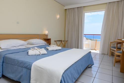 卡法斯Erytha Hotel & Resort Chios的酒店客房,配有带毛巾的床