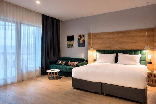 TarčinTarcin Forest Resort and Spa MGallery by Sofitel的一间卧室配有一张大床和一张沙发