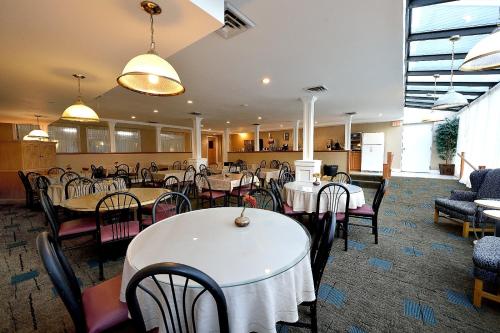 南雅茅斯使馆旅馆&套房酒店的一间设有白色桌椅的用餐室
