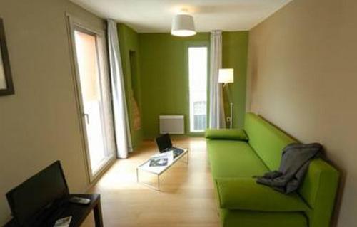 巴约讷汤波尔西当斯教堂酒店的客厅配有绿色沙发和桌子