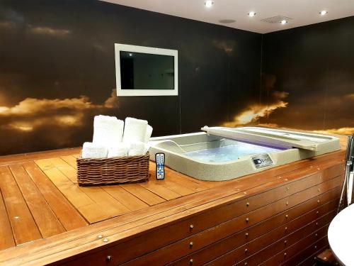 伦敦The Exhibitionist Hotel的木制甲板上的按摩浴缸和毛巾