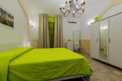 马鲁焦b&b Melina的一间卧室配有绿色的床和镜子