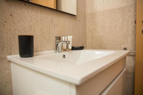 布拉加Design Flat in Braga - by TonsdeVerde的浴室设有白色水槽和镜子