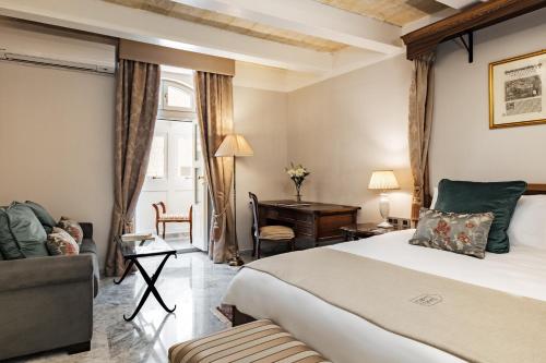 瓦莱塔帕莱斯勒布伦酒店的酒店客房设有一张大床和一张书桌。
