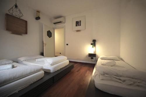 博洛尼亚多巴旅馆 的一间设有三张床的客房,墙上设有一台电视