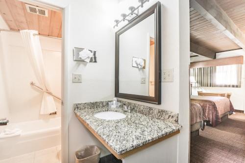 德里格斯提顿西部汽车旅馆的一间带水槽和镜子的浴室以及一张床