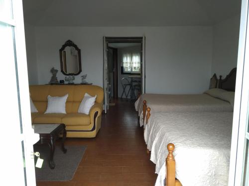 蓬德利马Residencial Retiro Sra. da Luz的一间卧室配有一张床、一张沙发和一面镜子