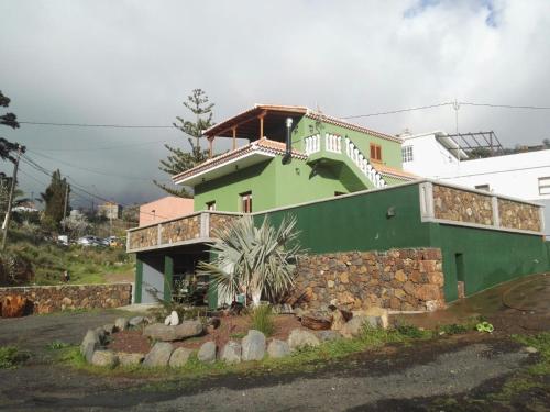 蓬塔戈尔达Casa Fagundo的一座绿色的白色房子,上面有楼梯