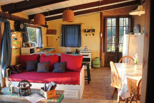 塞拉纳镇Odisea的客厅设有红色沙发,位于厨房内