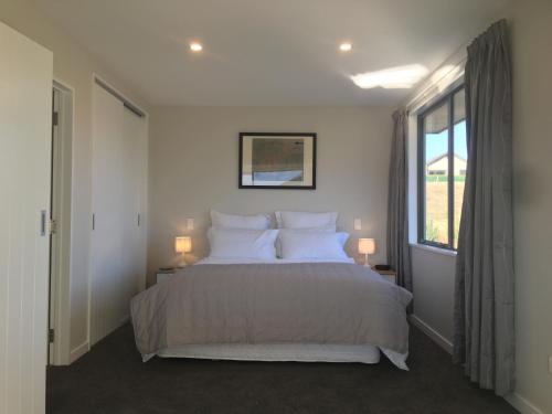 瓦纳卡尖塔岭度假旅馆的卧室配有带白色枕头的床和窗户。