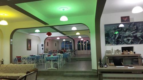 塞尔丘克尼西亚酒店的餐厅拥有绿色的天花板和桌椅