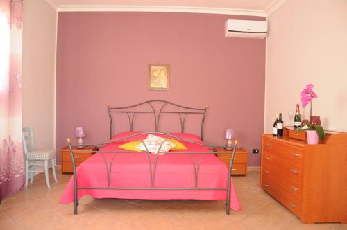 韦列Casa Vacanze Maralesi的卧室配有粉红色的床和梳妆台。