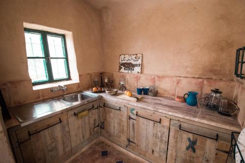 Ţabaqat FaḩlBeit Al Fannan的厨房配有木制橱柜、水槽和窗户。