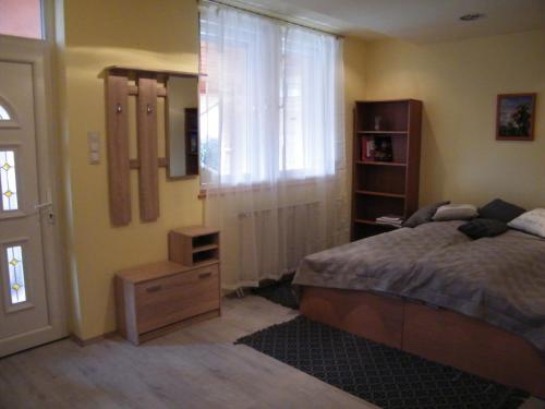 米什科尔茨Pál utcai Apartman Miskolc的一间卧室配有一张床、一个梳妆台和一扇窗户。