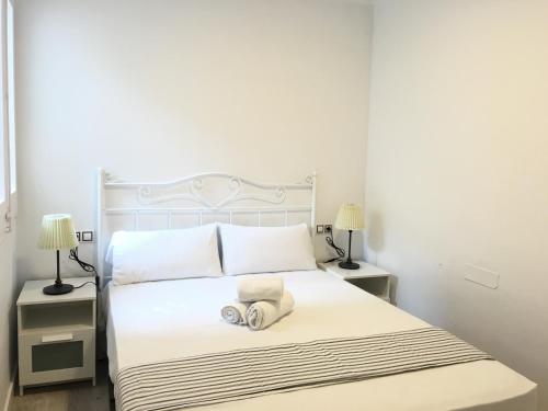 布拉内斯Aiguaneu Sa Carbonera的一间卧室配有白色床和2个床头柜