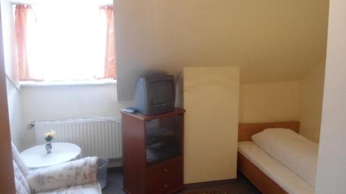 格斯韦因斯泰因克朗酒店的小房间设有床铺和橱柜上的电视
