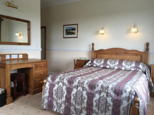 彭布罗克码头贝格里奇酒店的一间卧室配有一张床、一张书桌和一面镜子