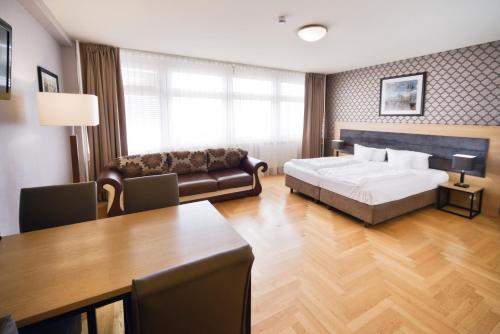 柏林AMC Apartments Ku'damm & Bundesallee的一间卧室配有一张床、一张沙发和一张桌子