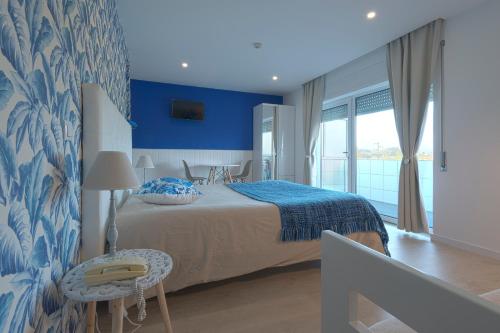库里亚库里亚俱乐部酒店的一间卧室配有一张蓝色墙壁的床