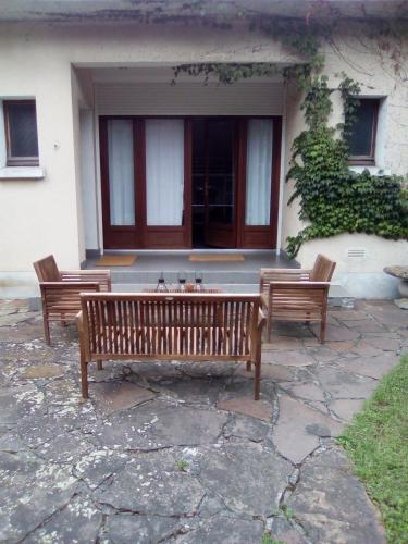 米朗德Villa Des Marronniers的两个木凳坐在大楼前