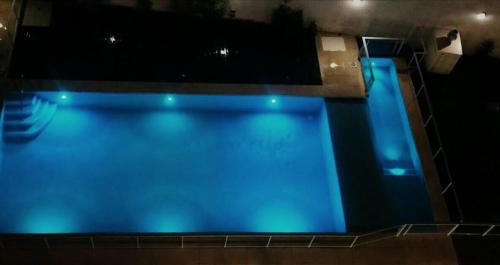 布宜诺斯艾利斯M & C Suites的夜间蓝色海水的大型游泳池