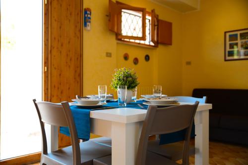 孔韦尔萨诺La civetta Rodonisa的一间配备有白色桌椅的用餐室
