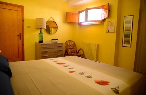 孔韦尔萨诺La civetta Rodonisa的一间卧室配有一张床、一个梳妆台和一扇窗户。