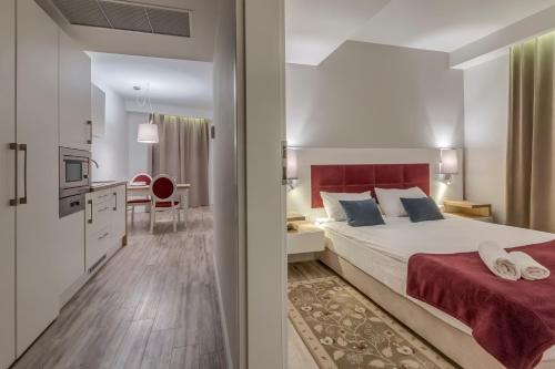 弗沃茨瓦韦克罗泽比基酒店的一间卧室配有一张大床和红色床头板