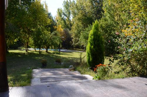 图努扬Casa de campo de piedra的一个带步道、树木和灌木的花园