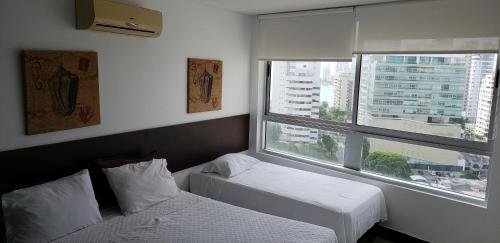 卡塔赫纳Palmetto Eliptic Bahia的酒店客房设有两张床和窗户。