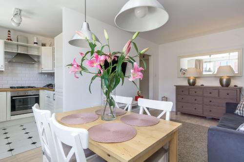 格但斯克Elite Apartments Center Grobla的厨房以及带粉红色花卉桌的用餐室