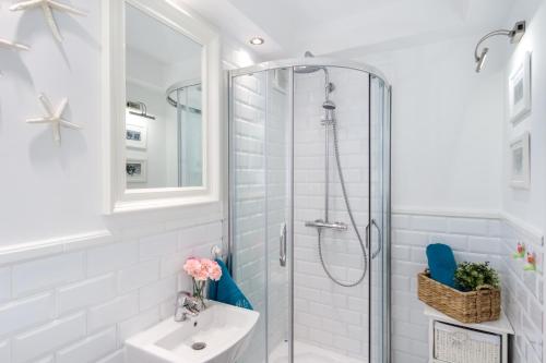 格但斯克Elite Apartments Center Grobla的带淋浴和盥洗盆的白色浴室