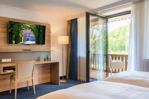 布拉姆舍IDINGSHOF餐厅&酒店的配有一张床、一张书桌和一扇窗户的酒店客房